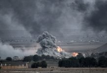 Explosion with smoke and fire in open landscape.