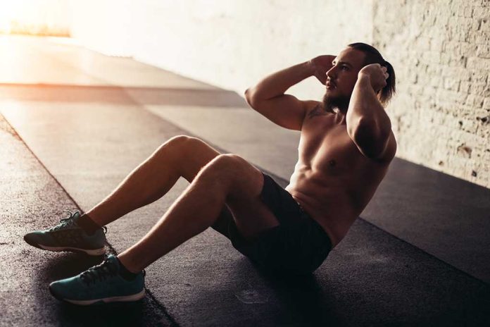 Man performing sit-ups in a gym setting.