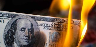 Burning hundred-dollar bill with visible flames.