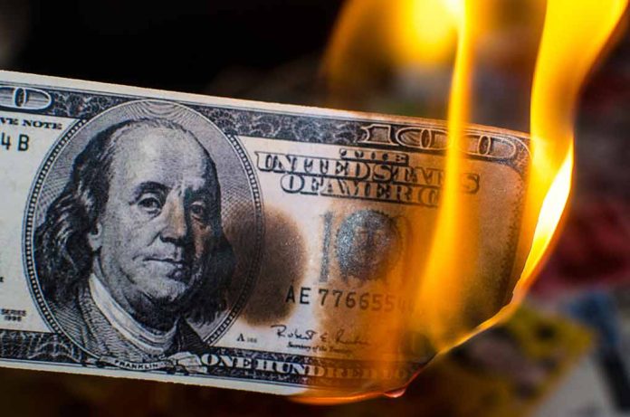 Burning hundred-dollar bill with visible flames.