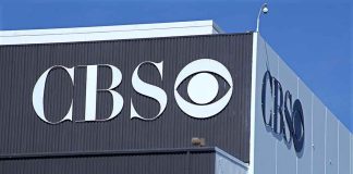 CBS logo on building exterior under blue sky.