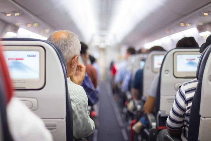 Passengers seated in airplane cabin with screens visible