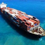 Cargo ship loaded with containers in blue ocean.