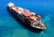 Cargo ship loaded with containers in blue ocean.