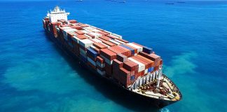 Cargo ship loaded with containers in blue ocean.