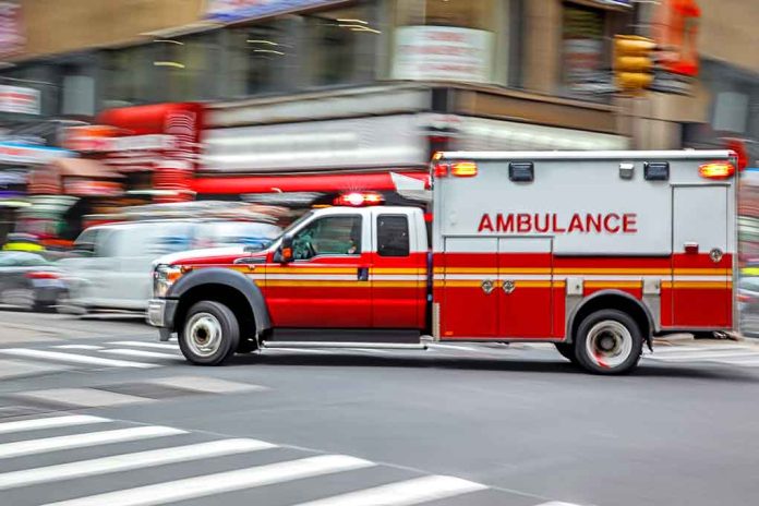 Red ambulance speeding through city intersection.