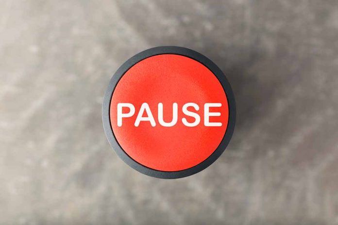 Red button labeled "PAUSE" on gray background.