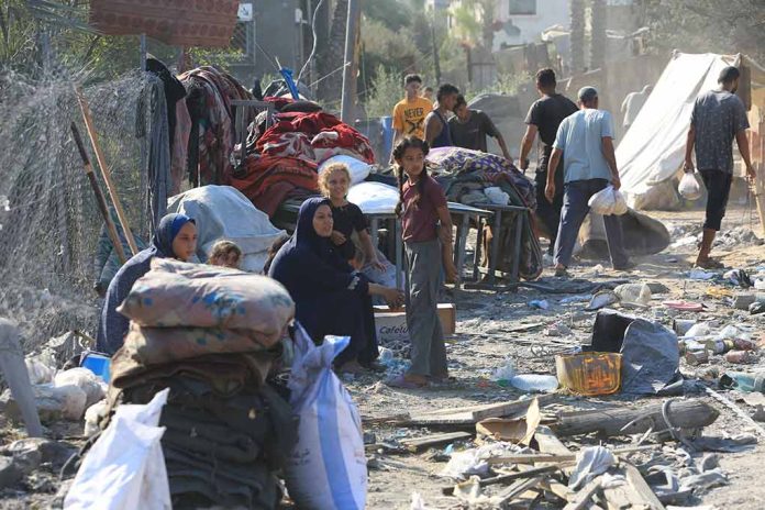 People in makeshift camp with tents and belongings.