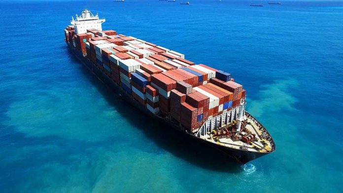 Cargo ship loaded with containers in blue ocean.