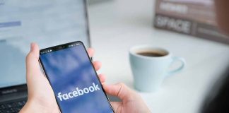 Person holding phone with Facebook app open