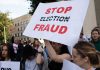 People holding Stop Election Fraud protest signs.