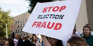 People holding Stop Election Fraud protest signs.