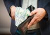 Person holding wallet with cash inside