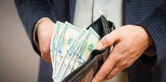 Person holding wallet with cash inside