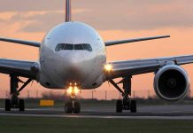 Airplane on runway during sunset with lights on