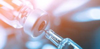 Syringe needle inserted into vaccine vial