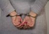Person in handcuffs wearing a gray sweater