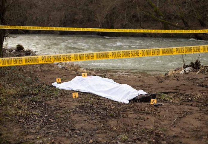 792627442 featured image Crime scene by river with covered body and markers