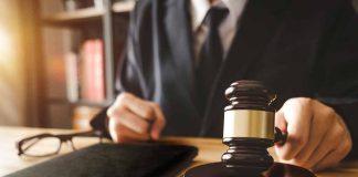 Gavel on table with glasses and notebook