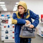 Person in store hiding something in a bag