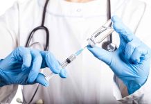 Doctor filling syringe with vaccine from vial