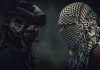 Two masked figures face each other dramatic lighting