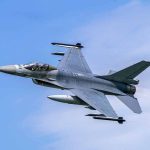 Jet fighter flying through clear blue sky