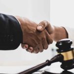Handshaking near a gavel on desk