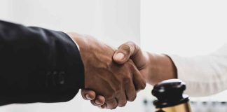 Handshaking near a gavel on desk