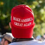 Red Make America Great Again hat on person head