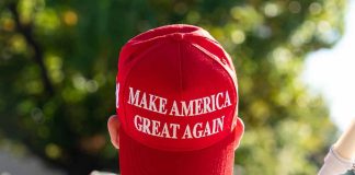 Red Make America Great Again hat on person head