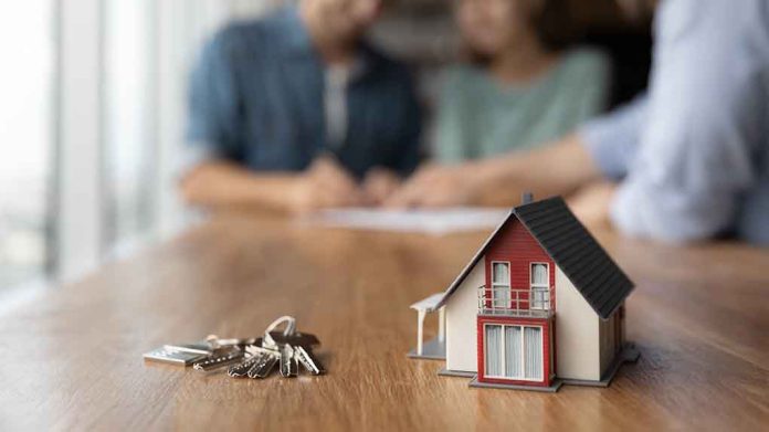 2022462029 featured image Model house and keys with couple signing documents.