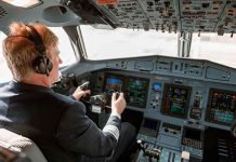 Pilot in cockpit operating airplane controls