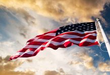 American flag waving against a cloudy sky