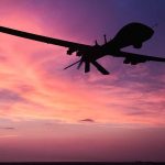 Silhouette of a drone against a colorful sunset