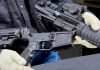 Person assembling a black rifle with gloves on