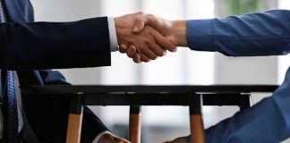 Handshake with money exchanged under table