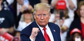 Man in suit making a fist gesture at rally