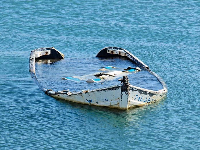 20081782 featured image Half submerged weathered abandoned boat floating on calm water