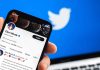 Twitter profile on smartphone screen with Twitter logo background