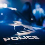 Police car with blurred figures in the background