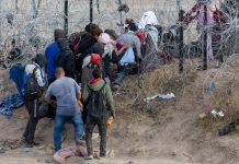 People near barbed wire fence in outdoor area