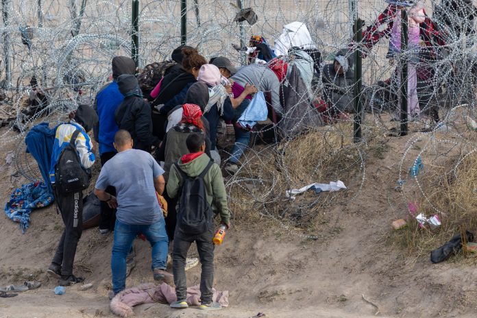 2497167393 featured image People near barbed wire fence in outdoor area