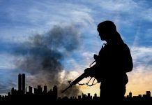 Silhouette of armed figure with smoky city skyline