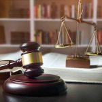 Gavel law book and scales in a library