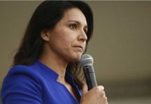 Woman in blue blazer holding a microphone
