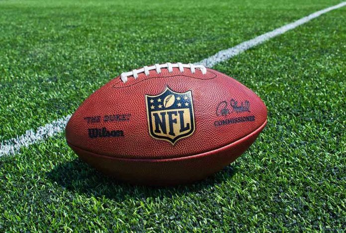 205708945 NFL football on a green field.