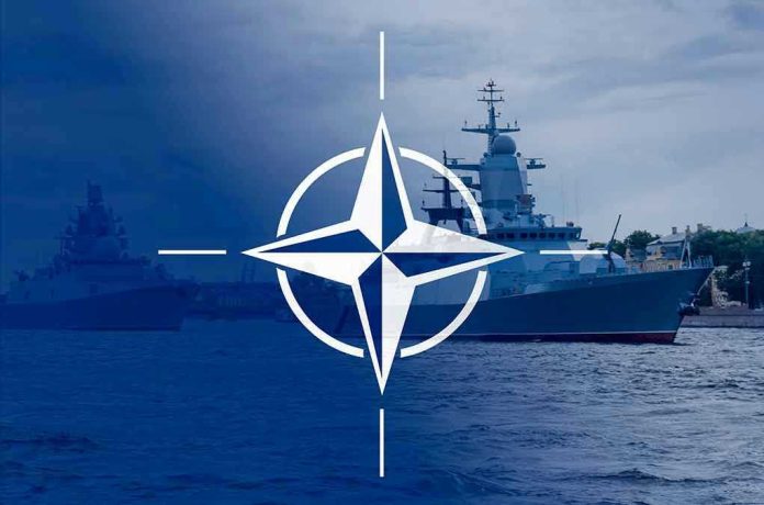 2113634360 NATO emblem overlaying naval ships in the ocean