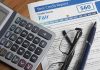 Calculator and glasses on credit report document