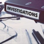 Documents and binder labeled Investigations on desk